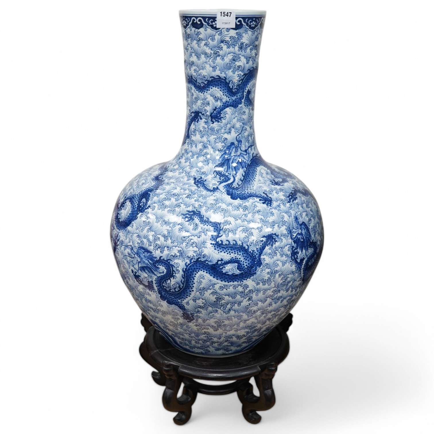 A large Chinese porcelain floor standing long necked vase, decorated with dragons, on a carved wood plinth, 103cm high. Condition - vase good, stand repaired